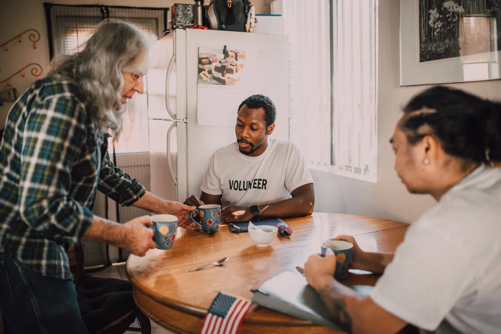 Three volunteers sharing coffee and ideas in a cozy kitchen setting, promoting community engagement. Donor retention: the parts worth your attention