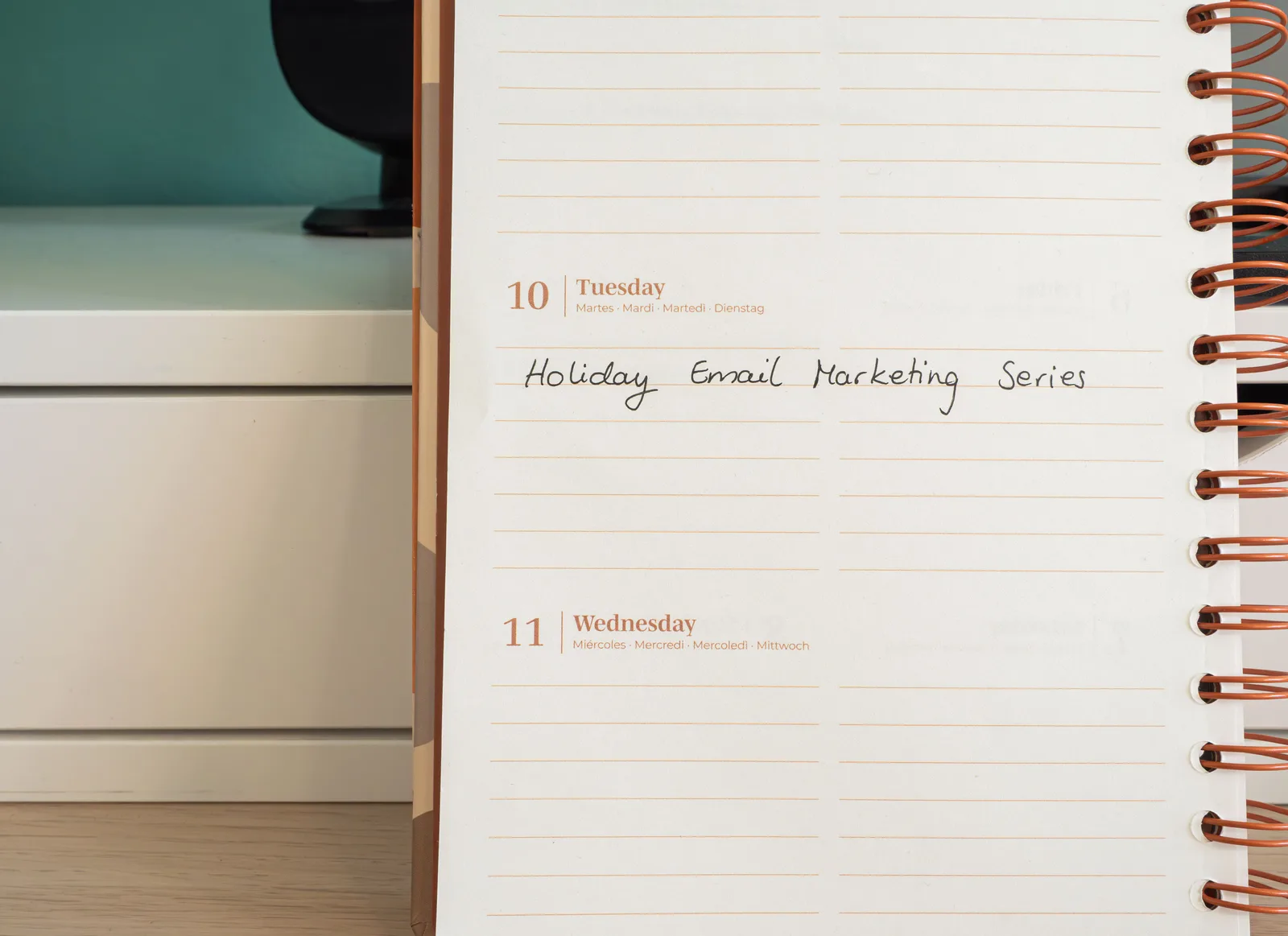 Planner open on a desk with handwritten 'Holiday Email Marketing Series' note. The nonprofit email marketing mistakes people repeat, and how to stop